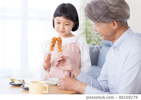 Girl eating Japanese sweets with grandpa Girl eating Japanese sweets with grandpa 98109279