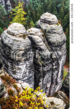 Rock formations in deep autumn forest 98110646