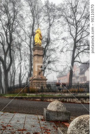 Marian column Immaculata in foggy park in city Ruzomberok, Slovakia 98110870
