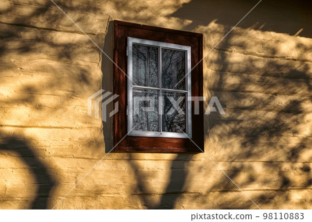 Old window on yel facade of wooden cottage Old window on yel facade of wooden cottage 98110883