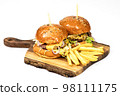 Two tasty american burgers on wooden serving board with fries. White background with copy space Two tasty american burgers on wooden serving board with fries. White background with copy space 98111175