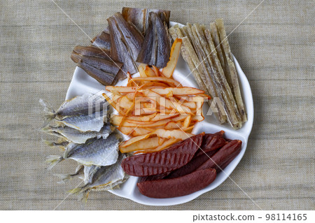 Plate with lots of beer snacks. Dried salted mackerel fish, cod fillets, squid and peppers, tuna and caviar Plate with lots of beer snacks. Dried salted mackerel fish, cod fillets, squid and peppers, tuna and caviar 98114165