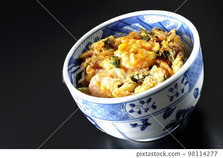 Kakiage rice bowl with vegetables and shrimp shot against a black background 98114277