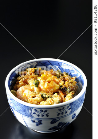 Kakiage rice bowl with vegetables and shrimp shot against a black background 98114286