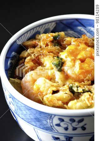 Kakiage rice bowl with vegetables and shrimp shot against a black background 98114289