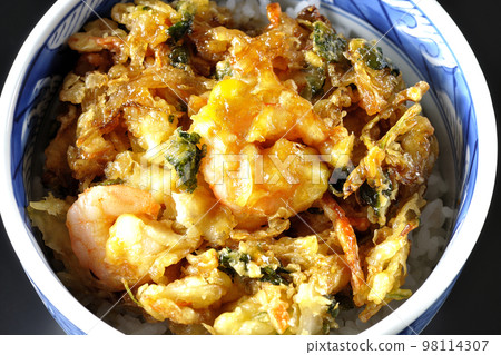 A bird's-eye view of vegetables and shrimp kakiage rice bowl on a black background 98114307