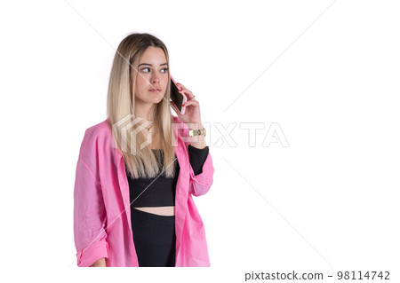 Young blonde woman standing talking to her cell phone looking away against white background 98114742