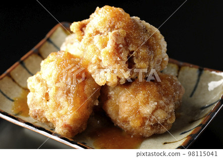 Tatsuta-age chicken with ponzu sauce and grated daikon radish on a black background 98115041