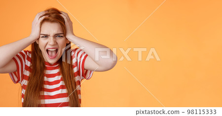 Pissed fed up redhead female teenager annoyed, break down, grab head yelling hateful displeased, depressed, upset failure, stand angry disappointed, panic, shouting aggressive orange background 98115333