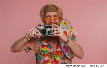 Happy young man tourist photographer taking photos on retro camera and smiling, holiday vacation Happy young man tourist photographer taking photos on retro camera and smiling, holiday vacation 98115464