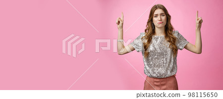 Darling please buy it. Whining clingy upset sad cute european girlfriend begging boyfriend pointing up showing awesome stylish new product pursing lips expressing jealousy regret, pink background 98115650