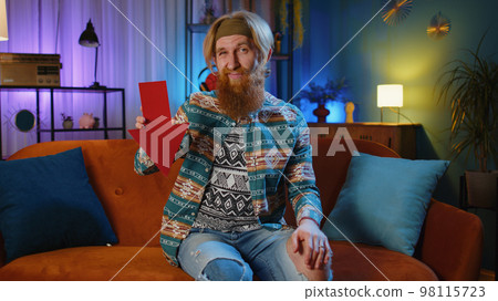 Upset hippie man showing red arrow pointing down, concept of downgrade bankruptcy money fail, fall Upset hippie man showing red arrow pointing down, concept of downgrade bankruptcy money fail, fall 98115723