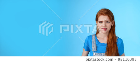 Uneasy upset redhead girl feel uncomfortable, stare frustrated, biting lip frowning, pull sad face upset, apologizing friend, express pity dilsike, stare doubtful uncertain, make bad choice 98116395