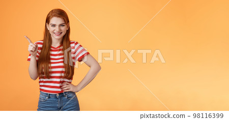 Cheerful sly redhead girlfriend have something interesting on mind, squinting cunning joyful smile, hold hand waist confident pose, pointing upper left corner give recommendation, orange background Cheerful sly redhead girlfriend have something interesting on mind, squinting cunning joyful smile, hold hand waist confident pose, pointing upper left corner give recommendation, orange background 98116399