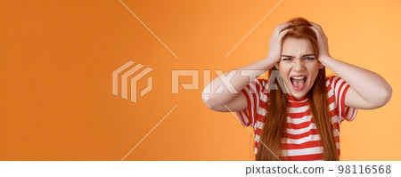 Pissed fed up redhead female teenager annoyed, break down, grab head yelling hateful displeased, depressed, upset failure, stand angry disappointed, panic, shouting aggressive orange background 98116568