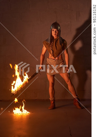 Female viking with burning sword before fight 98118192