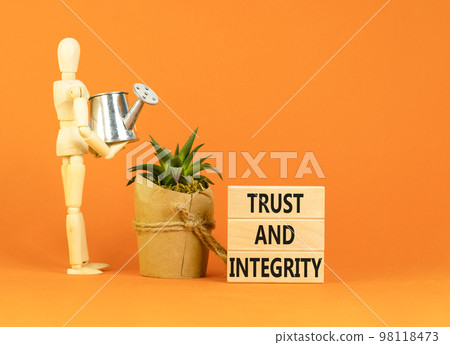 Trust and integrity symbol. Concept words Trust and integrity on wooden blocks. Businessman model. Beautiful orange background. Business, psychological and trust and integrity concept. Copy space. Trust and integrity symbol. Concept words Trust and integrity on wooden blocks. Businessman model. Beautiful orange background. Business, psychological and trust and integrity concept. Copy space. 98118473