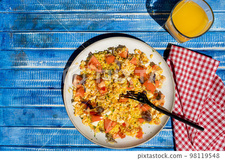 Plate with homemade chicken salad, carrot, tomato and brown rice on a rustic blue wooden table. Aereal view. Plate with homemade chicken salad, carrot, tomato and brown rice on a rustic blue wooden table. Aereal view. 98119548