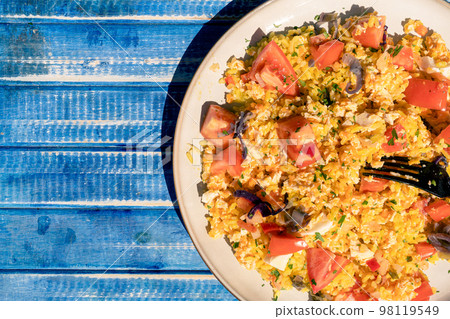 Plate with homemade chicken salad, carrot, tomato and brown rice on a rustic blue wooden table. Aereal view. Plate with homemade chicken salad, carrot, tomato and brown rice on a rustic blue wooden table. Aereal view. 98119549