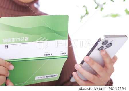 A woman looking at a savings passbook A woman looking at a savings passbook 98119564