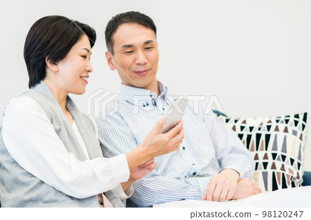 看智能手機的中年夫婦 98120247