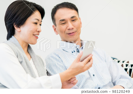 看智能手機的中年夫婦 98120249