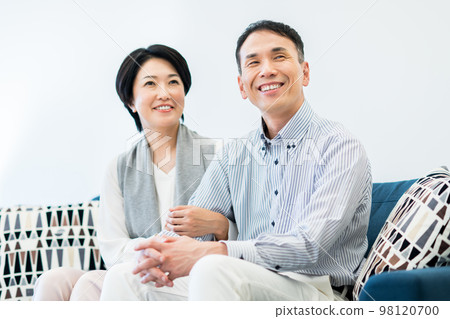Middle couple relaxing in the living room Middle couple relaxing in the living room 98120700