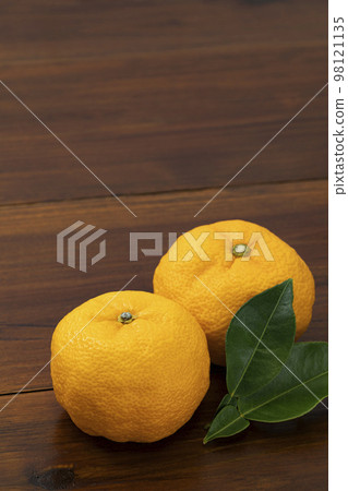 Yuzu arranged on a board with leaves 98121135