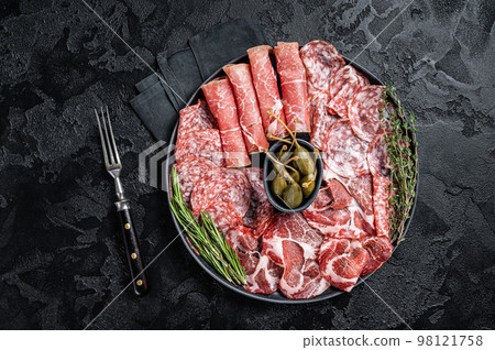 Italian Antipasto set platter, cured meat plate with Prosciutto crudo, Salami and Coppa Sausage. Black background. Top view Italian Antipasto set platter, cured meat plate with Prosciutto crudo, Salami and Coppa Sausage. Black background. Top view 98121758