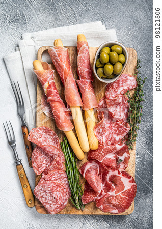 Antipasto platter cold meat plate with grissini bread sticks, Prosciutto crudo, Salami and Coppa Sausage. White background. Top view 98121806