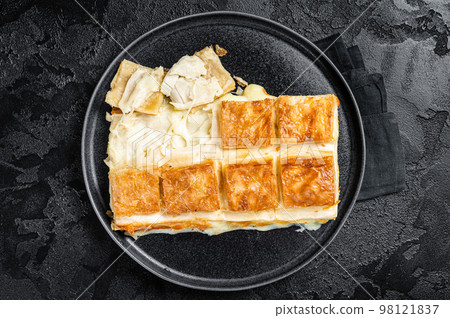 Turkish Su Boregi pie, Tabla borek or burek in plate. Black background. Top view Turkish Su Boregi pie, Tabla borek or burek in plate. Black background. Top view 98121837