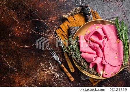 Slices of Salami with pistachios nuts in steel plate with thyme and rosemary. Dark background. Top view. Copy space Slices of Salami with pistachios nuts in steel plate with thyme and rosemary. Dark background. Top view. Copy space 98121839
