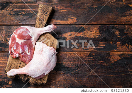 Uncooked Raw duck legs, Poultry meat on a wooden board. Wooden background. Top view. Copy space 98121880