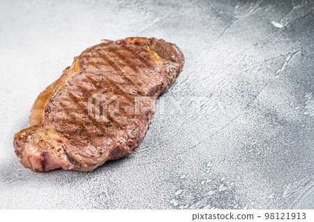 Grilled New York striploin beef meat steak. White background. Top view. Copy space Grilled New York striploin beef meat steak. White background. Top view. Copy space 98121913