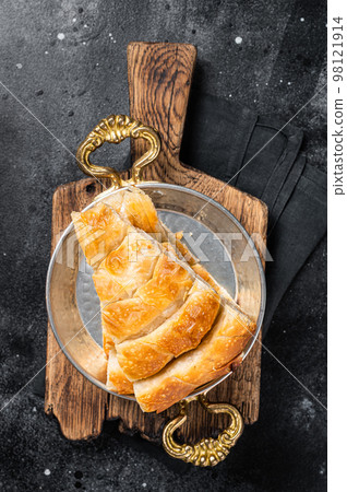 Traditional feta cheese phyllo pastry pie in rustic skillet. Black background. Top view 98121914