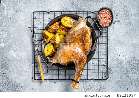 Baked Guineafowl, guinea fowl with potato in steel tray. Gray background. Top view Baked Guineafowl, guinea fowl with potato in steel tray. Gray background. Top view 98121957