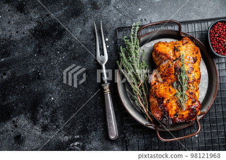Roasted Glazed Pork meat Roll with thyme and tomato sauce. Black background. Top view. Copy space 98121968