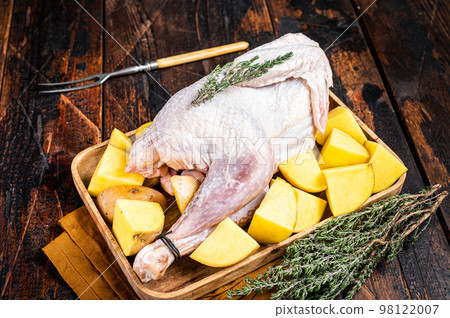 Fresh Raw Guineafowl, guinea fowl with potato, game bird. Wooden background. Top view Fresh Raw Guineafowl, guinea fowl with potato, game bird. Wooden background. Top view 98122007