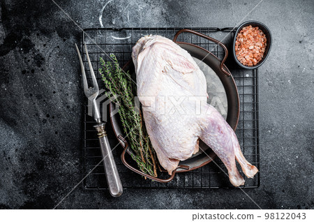 Raw Guineafowl, guinea fowl with herbs in steel tray. Black background. Top view Raw Guineafowl, guinea fowl with herbs in steel tray. Black background. Top view 98122043