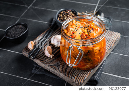 Homemade kimchi in a glass jar, traditional Korean cuisine. Black background. Top view Homemade kimchi in a glass jar, traditional Korean cuisine. Black background. Top view 98122077