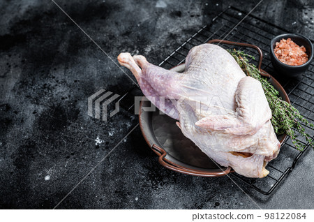 Raw Guineafowl, guinea fowl with herbs in steel tray. Black background. Top view. Copy space Raw Guineafowl, guinea fowl with herbs in steel tray. Black background. Top view. Copy space 98122084