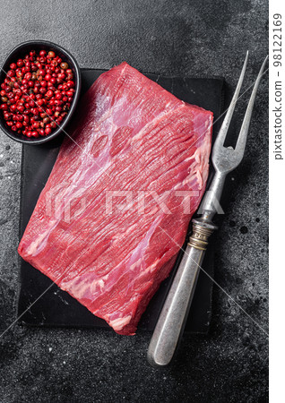Prime choice flank steak, raw beef meat on marble board with herbs. Black background. Top view Prime choice flank steak, raw beef meat on marble board with herbs. Black background. Top view 98122169
