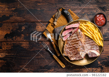 Roast Italian Florentine or porterhouse beef meat Steak in a plate with french fries. Wooden background. Top view. Copy space 98122182