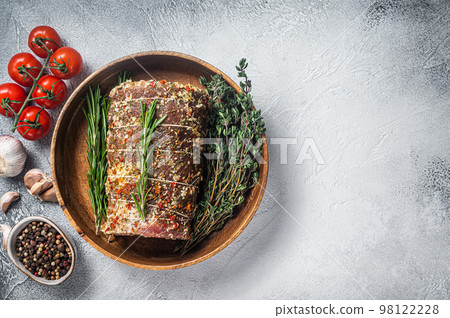 Raw italian Porchetta seasoned with herbs, pork meat roll. White background. Top view. Copy space 98122228