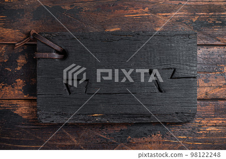 Black wooden Cutting board on kitchen table. Wooden background. Top view. Copy space Black wooden Cutting board on kitchen table. Wooden background. Top view. Copy space 98122248