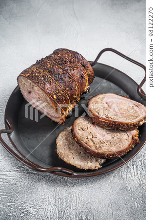 Sliced roast pork meat roulade on a steel tray. White background. Top view 98122270