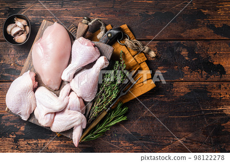 Assortment of chicken portions for Bbq grilling. Raw parts - drumstick, breast fillet, wings, thigh. Wooden background. Top view. Copy space Assortment of chicken portions for Bbq grilling. Raw parts - drumstick, breast fillet, wings, thigh. Wooden background. Top view. Copy space 98122278