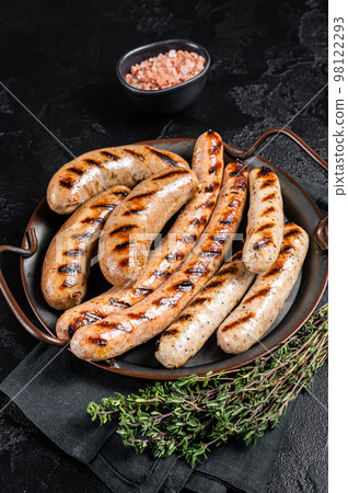 Grilled Bratwurst meat sausages on a steel tray with herbs. Black background. Top view Grilled Bratwurst meat sausages on a steel tray with herbs. Black background. Top view 98122293
