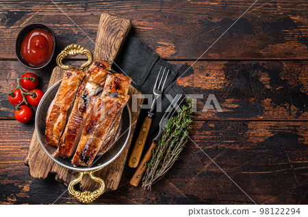 Barbecue chopped pork spare ribs in a skillet. Wooden background. Top view. Copy space Barbecue chopped pork spare ribs in a skillet. Wooden background. Top view. Copy space 98122294