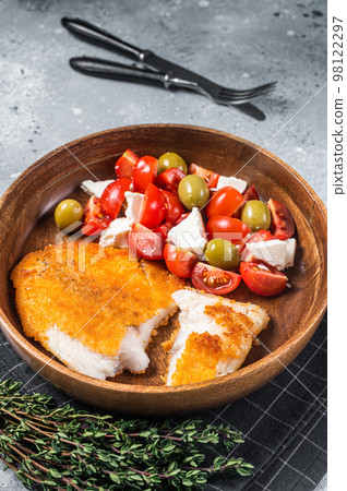 Fried tilapia fillet on a plate with salad. Gray background. Top view Fried tilapia fillet on a plate with salad. Gray background. Top view 98122297